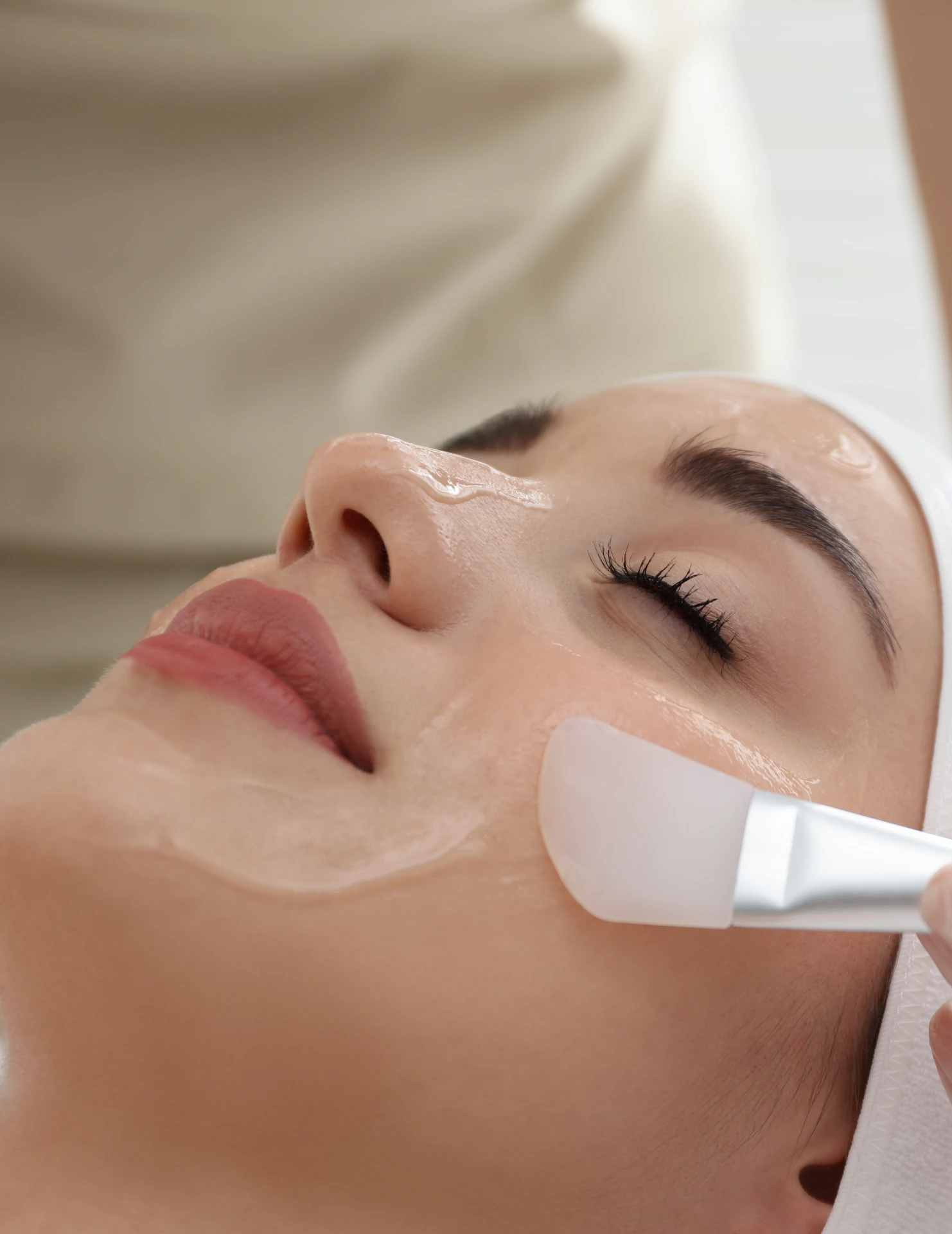 cream being applied all over a woman's face