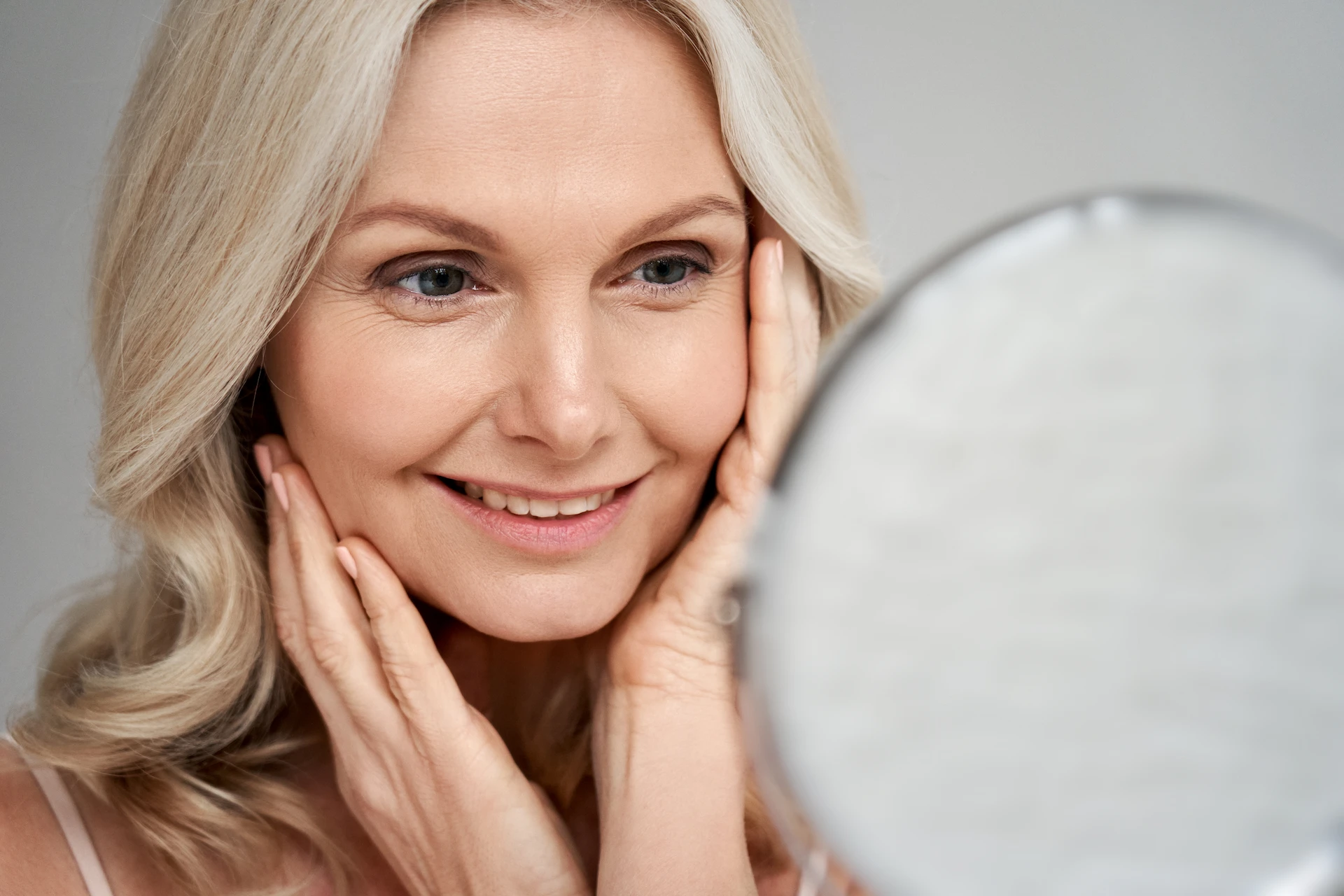 woman checking out her face in a mirror