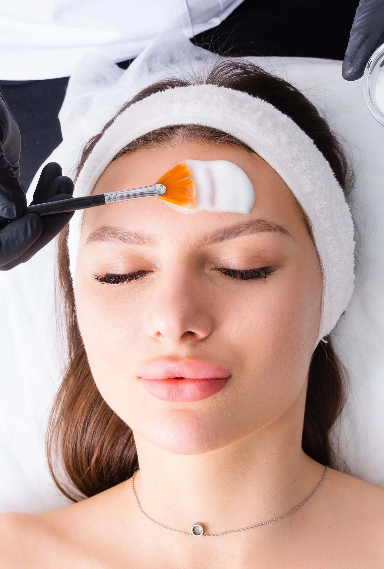 woman having cream applied to her head